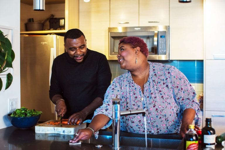 Couple cooking and cleaning in kitchen; bamboo paper towels