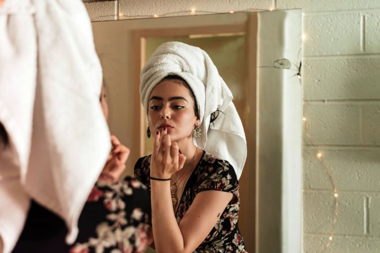 Woman putting on makeup after a shower; bamboo shower caddies