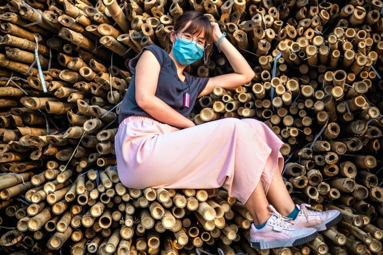 Woman laying on bamboo poles; bamboo products